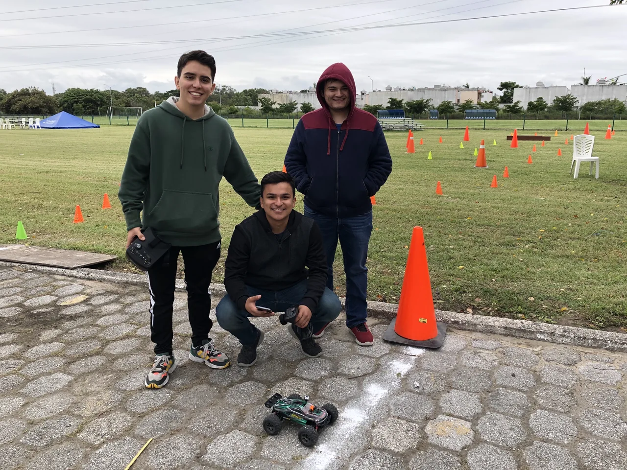 A LASIRS ground-vehicle team beside their wheeled robot and a course marked with cones.